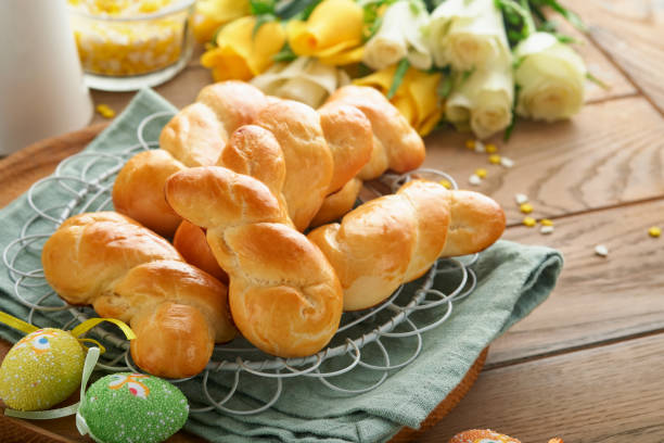 istock Easter breakfast Holliday concept. Easter bunny buns rolls with cinnamon made from yeast dough with orange glaze, easter decorations, colored eggs on old wooden background. Easter Holliday card. 1467028957