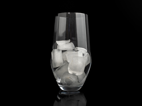 Glass with ice on a black background. Close-up.