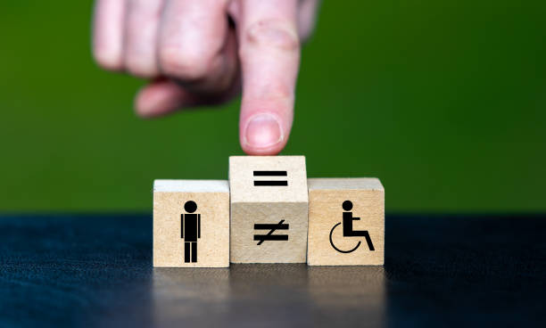 Symbol for equal rights of persons with disabilities. Hand turns wooden cube and changes the unequal sign to a equal sign. stock photo