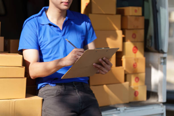istock Asian courier with parcel and delivery logistic concept. Delivery man with checking list on clipboard 1467032917