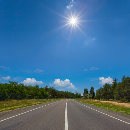 long asphalt road  under sparkle sun