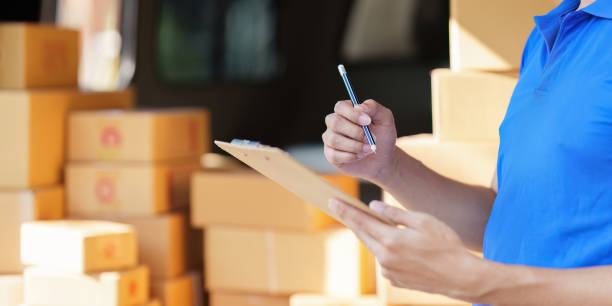 istock Asian courier with parcel and delivery logistic concept. Delivery man with checking list on clipboard 1467034712
