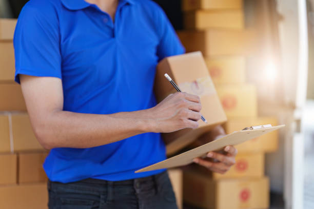 Asian courier with parcel and delivery logistic concept. Delivery man with checking list on clipboard