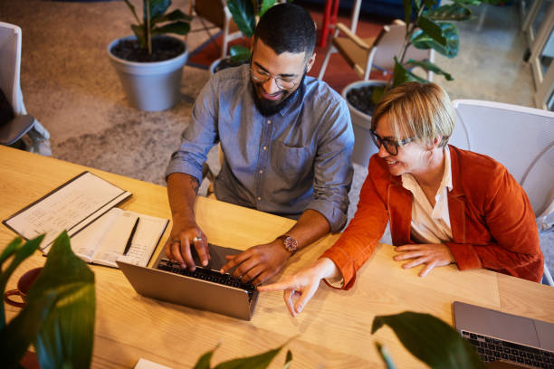 istock Diverse businesspeople smiling and working on a laptop in an office 1467035683