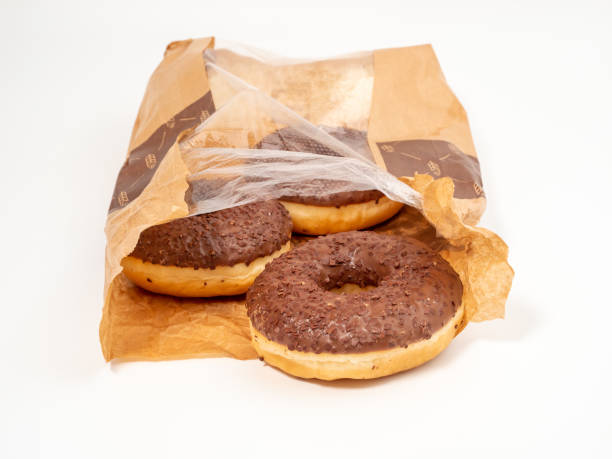 istock Chocolate donut with chocolate chips in a paper bag on a white background. 1467035718