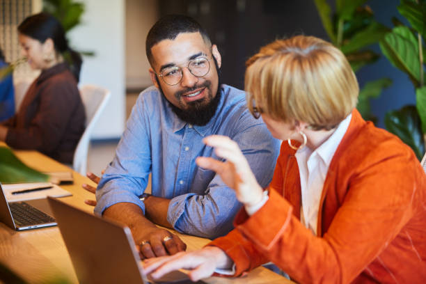 istock Diverse businesspeople smiling and talking while working at an office table 1467035802