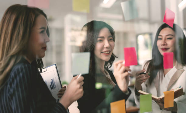 istock Young creative business people meeting at office, using sticky note analysing and presenting business plan on the wall. 1467037989