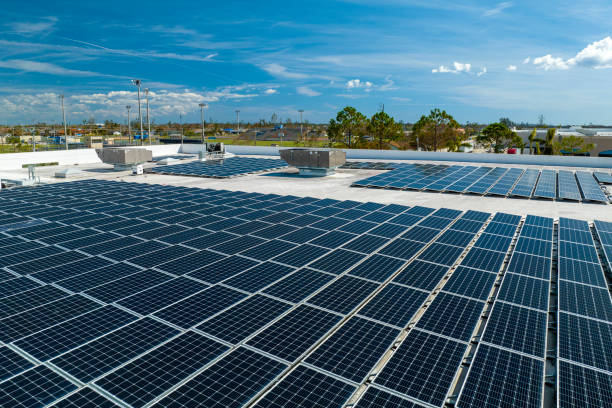 vue aérienne de panneaux solaires photovoltaïques bleus montés sur le toit d’un bâtiment industriel pour produire de l’électricité écologique propre. concept de production d’énergie renouvelable - production dénergie photos et images de collection