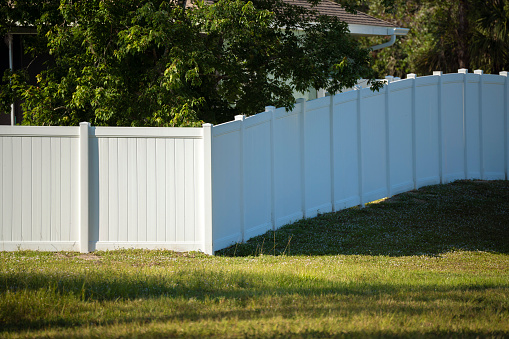 White plastic fence for back yard protection and privacy.