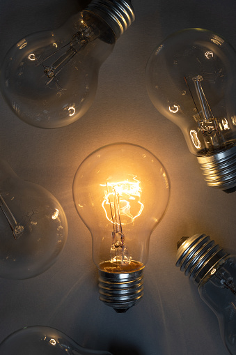 Idea concept with classic light bulb glowing in the dark. This file is cleaned and retouched.