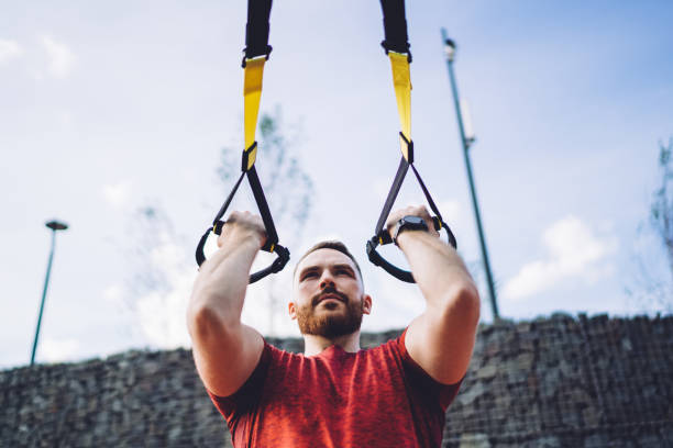 istock Determined man working out on TRX straps 1467041858