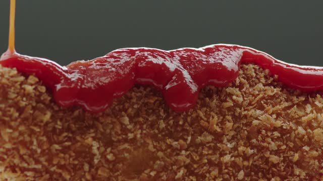 ketchup macro falling into fried chicken nuggets in slow motion with zoom in