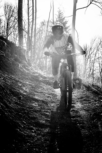 Black and white image of a Young woman on a downhill bicycle
