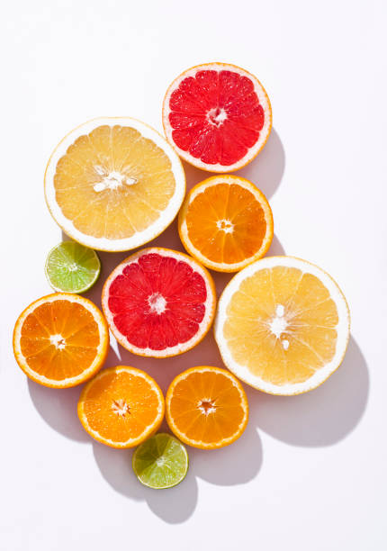 istock Fresh citrus fruit: oranges, red blood oranges(tarocco), pomelo, lime om the white background , sunlight, top view 1467048109