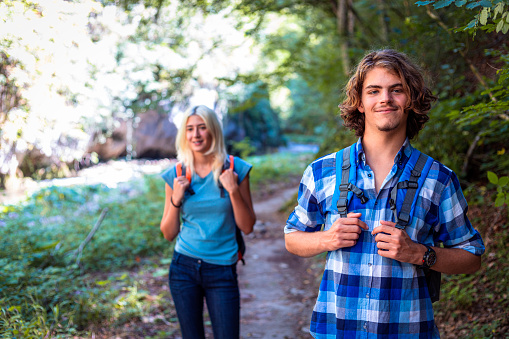 Young adult couple enjoying in hiking through the river canyon