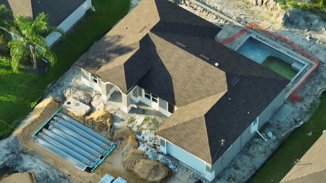 Aerial view of suburban private house with yard ground works, septic drain field installation and swimming pool under construction in Florida quiet rural area