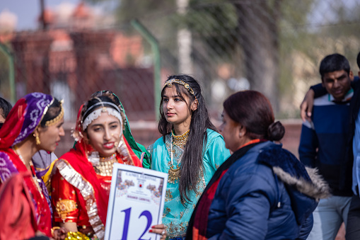 Bikaner, Rajasthan, India - January 2023: Camel festival bikaner, Group of young beautiful girls in traditional dress and jewellery of rajasthan while participating in the parade of camel festival in bikaner city. Selective focus.