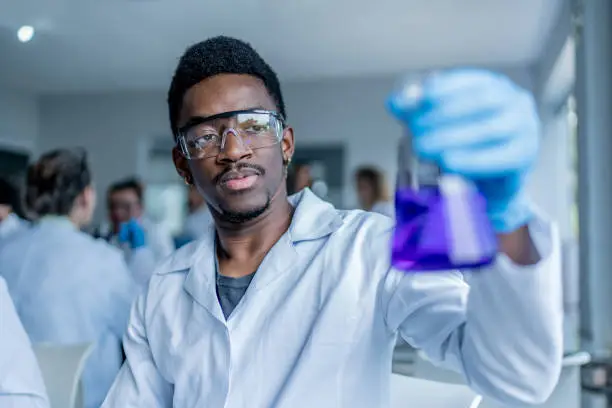 Photo of College student examining liquid in the lab