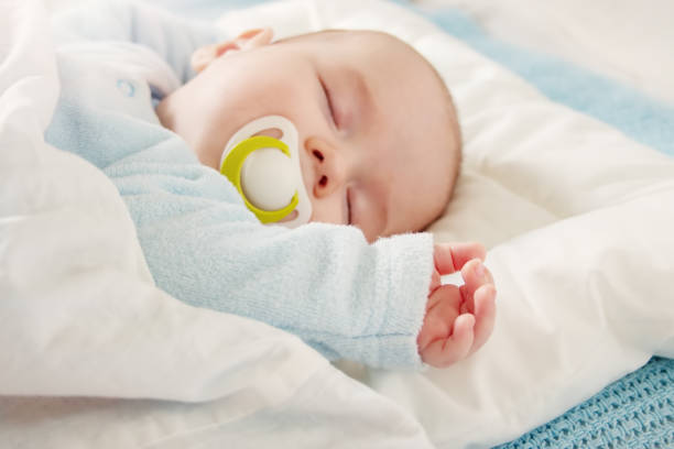 istock Cute three month old baby sleeping in comfortable bed. 1467055166