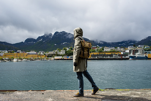 Man on the pier enjoying the scenic views. Ocean and rocks landscape. Travel, adventure. Feeling of freedom, lifestyle. Explore Northern Norway. Summer in Scandinavia