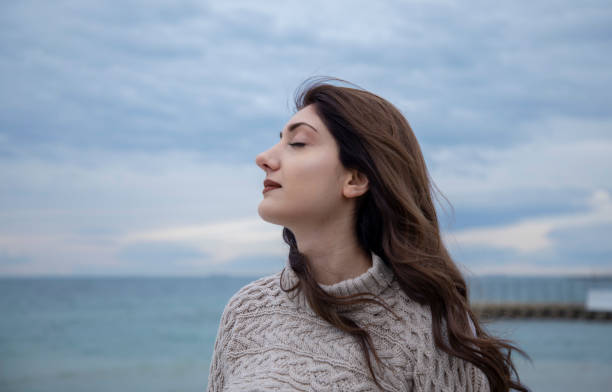 istock young beautiful woman is breathing on the beach 1467064583