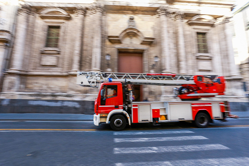 Small Fire truck flies to the fire quickly on asphalt street of Catania, Sicily