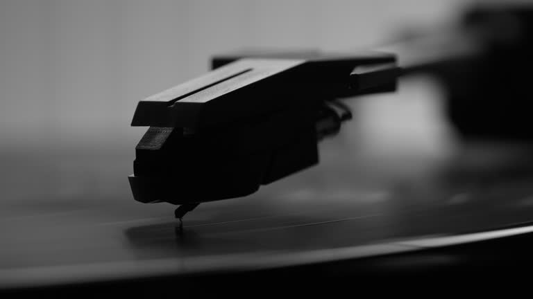 Vinyl record- turntable and Stylus. Panning left to right. Close up black and white.