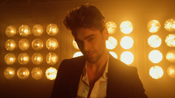 istock Man model moving backwards in spotlights close up. Guy walking on club stage. 1467070909