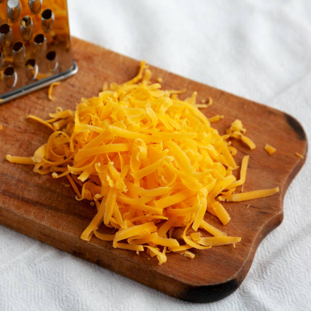 istock Shredded Sharp Cheddar Cheese on a rustic wooden board, low angle view. Close-up. 1467073068