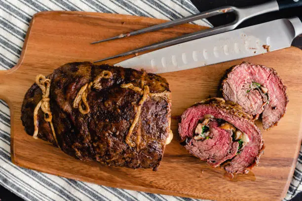 Slices of steak roulade stuffed with mushrooms, provolone, and arugula