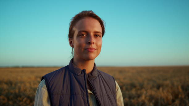 Portrait smiling farmer posing at grain field. Beautiful rural landscape view.