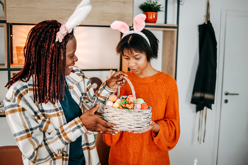 Mother and daughter holding a basket with Easter eggs