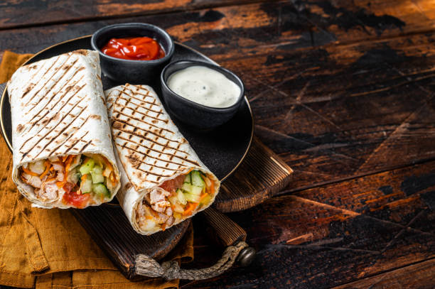istock Shawarma, Shaurma chicken roll  with  vegetable salad. Wooden background. Top view. Copy space 1467074672