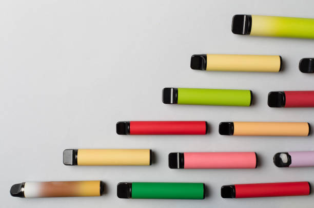 istock Disposable electronic cigarettes on color background, top view 1467074784