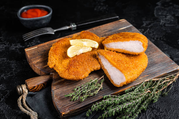 escalope de ternera vienesa, filete de schnitzel de carne frita. fondo negro. vista superior - viennese schnitzel fotografías e imágenes de stock