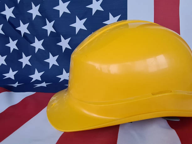 istock Closeup of construction hard hat and USA flag 1467076055
