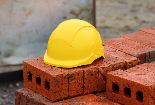 Yellow helmet on top of red brick