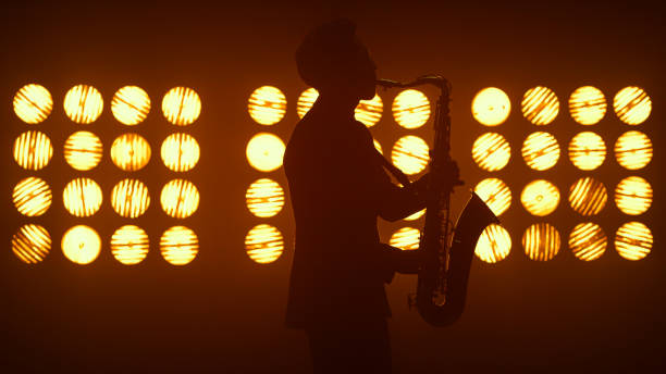 istock Unknown jazz man saxophonist performing on stage. Player holding modern sax. 1467095642