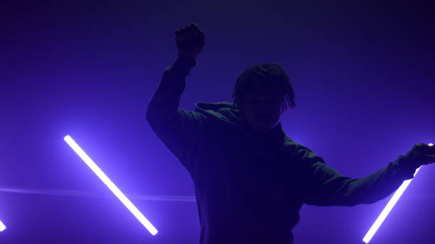 istock Silhouette b-boy making hands movements breakdance in club. Guy dancing hiphop 1467098419