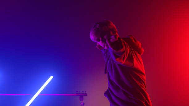 istock Handsome dancer showing shooting gesture breakdancing in nightclub neon lights. 1467098975