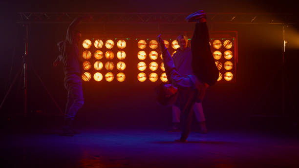 istock Breakdance crew making tricks on dance floor. Silhouettes hip hop team on stage. 1467102750
