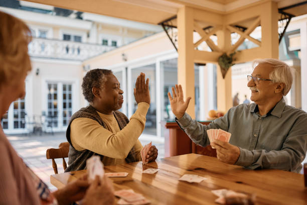 istock Happy senior men giving high-five while playing cards at nursing home. 1467102852