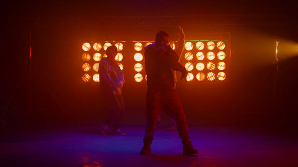 istock Dancing team silhouette performing modern movements in nightclub backlight. 1467102916