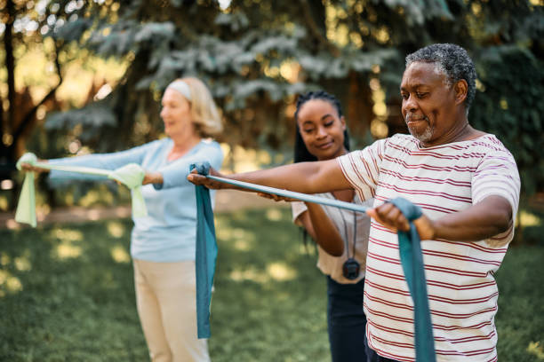 istock Black senior man practicing with power band on exercise class at residential care home. 1467102944
