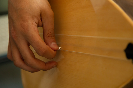 Human hand playing saz. Close-up. Turkish traditional instrument \