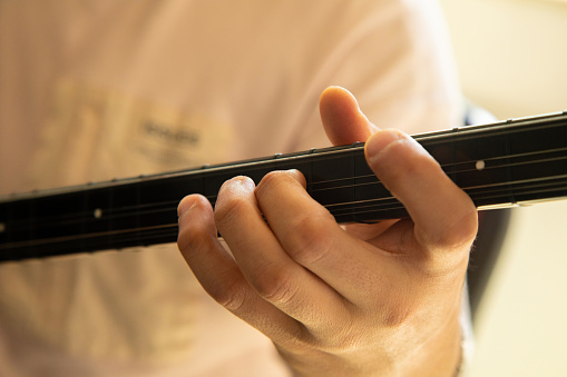 Human hand playing saz. Close-up. Turkish traditional instrument \