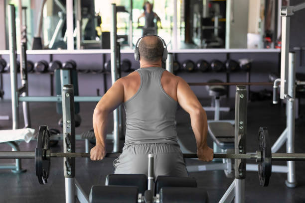 istock Man carrying weights in front of the mirror 1467107982
