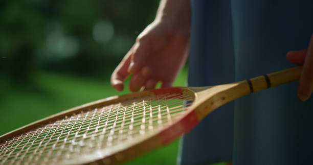 istock Closeup child hand holding badminton racket examining net. Active hobby concept 1467110084