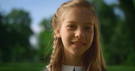 Close up photo portrait of a little blonde girl on a summer day