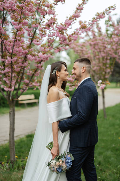 istock newlyweds walk in the park among cherry blossoms 1467110450